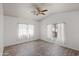 Light-filled bedroom with wood-look floors, a ceiling fan, and bright windows at 725 W Beth Dr, Phoenix, AZ 85041
