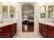 View of a bathroom with double vanity sinks and a view into the main bedroom through an arched entryway at 816 W Sycamore Ct, Litchfield Park, AZ 85340