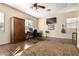 Bonus room features a ceiling fan, wall-mounted TV, and large area rug over wood-look flooring at 816 W Sycamore Ct, Litchfield Park, AZ 85340