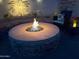 Cozy backyard fire pit with built-in seating and decorative stone, perfect for relaxing evenings at 816 W Sycamore Ct, Litchfield Park, AZ 85340