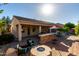 This home's outdoor space features a firepit, outdoor kitchen, and covered patio under a bright, sunny sky at 816 W Sycamore Ct, Litchfield Park, AZ 85340
