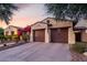 Spacious three-car garage with dark wood doors and a paved driveway, enhancing the home's curb appeal at 816 W Sycamore Ct, Litchfield Park, AZ 85340