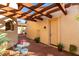 Inviting covered patio with a wrought-iron table and chairs, set beneath a wooden pergola, beside a door at 816 W Sycamore Ct, Litchfield Park, AZ 85340