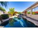 Serene backyard pool with mature trees and a red umbrella, perfect for relaxation and entertainment at 816 W Sycamore Ct, Litchfield Park, AZ 85340