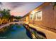 A beautiful backyard with pool view showing desert landscaping and home's exterior under a dusk sky at 816 W Sycamore Ct, Litchfield Park, AZ 85340