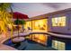 Inviting pool and patio area with cozy seating, covered lanai, and colorful umbrella under a twilight sky at 816 W Sycamore Ct, Litchfield Park, AZ 85340