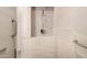 Modern shower with decorative pebble tile accent, grab bars, and sleek fixtures for safety and style at 816 W Sycamore Ct, Litchfield Park, AZ 85340