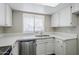 Bright kitchen featuring stainless steel dishwasher, sink, white cabinets and countertops at 818 S Westwood -- # 101, Mesa, AZ 85210