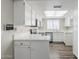 Well-lit kitchen boasts white cabinets, stainless steel appliances, and low-maintenance wood-look flooring at 818 S Westwood -- # 101, Mesa, AZ 85210
