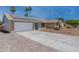 Front exterior showcasing a brick home, expansive driveway, and environmentally friendly solar panels at 962 W Keating Ave, Mesa, AZ 85210