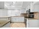 Well-lit kitchen with white cabinets, granite countertops, and modern stainless steel appliances at 962 W Keating Ave, Mesa, AZ 85210
