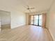 Bright living room featuring wood flooring and a sliding glass door to the balcony at 10330 W Thunderbird Blvd # B313, Sun City, AZ 85351