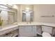 A bright bathroom featuring a vanity with a sink, a toilet, and a shower over tub at 10619 W Loma Blanca Dr, Sun City, AZ 85351