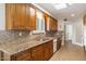 A kitchen with brown cabinets, granite countertops, a stainless steel sink, and modern appliances at 10619 W Loma Blanca Dr, Sun City, AZ 85351