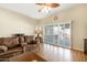 Well-lit living room with comfortable seating, wood floors, and sliding glass doors providing ample natural light at 10619 W Loma Blanca Dr, Sun City, AZ 85351