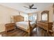 Serene bedroom with wood furnishings, tile floors, decorative headboard, and a view of a nice backyard at 10619 W Loma Blanca Dr, Sun City, AZ 85351