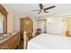 Bright bedroom with vintage furniture, a ceiling fan, and a view of a nice backyard at 10619 W Loma Blanca Dr, Sun City, AZ 85351