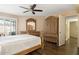 A cozy main bedroom features wood-look tile floors, a ceiling fan, and matching furnishings at 10619 W Loma Blanca Dr, Sun City, AZ 85351