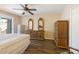 A cozy main bedroom features wood-look tile floors, ceiling fan, and matching dressers at 10619 W Loma Blanca Dr, Sun City, AZ 85351