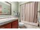 Bathroom with a sink, toilet, and tiled shower with curtain at 10860 W Buccaneer Dr, Sun City, AZ 85351
