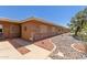 Tan home featuring desert landscaping with brick accents and neutral-toned exterior at 10860 W Buccaneer Dr, Sun City, AZ 85351