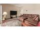Comfortable living room features a large leather couch and plush ottoman at 10860 W Buccaneer Dr, Sun City, AZ 85351