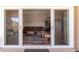 View from the patio of the living room with a brown leather sofa set and area rug at 10860 W Buccaneer Dr, Sun City, AZ 85351