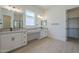 Primary bathroom featuring double sinks, granite counters, and a walk-in closet at 11002 N 164Th Dr, Surprise, AZ 85388