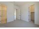 Neutral bedroom with carpet flooring and adjoining bathroom and closet entrances at 11002 N 164Th Dr, Surprise, AZ 85388
