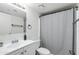 Bright bathroom featuring a shower with a gray curtain, white vanity, and fixtures at 12123 W Bell Rd # 219, Surprise, AZ 85378