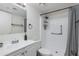 Bright bathroom featuring a shower with a gray curtain, white vanity, and fixtures at 12123 W Bell Rd # 219, Surprise, AZ 85378