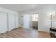 Bright bedroom with wood-look floors, closet space, and sliding glass door to a balcony area at 12123 W Bell Rd # 219, Surprise, AZ 85378