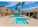 Inviting community pool and jacuzzi surrounded by palm trees in a well-kept community at 12123 W Bell Rd # 219, Surprise, AZ 85378