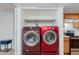 Compact laundry area with stacked red washer and dryer and shelving above at 12123 W Bell Rd # 219, Surprise, AZ 85378