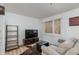 Cozy living room offers wood-look floors, comfortable seating, and a modern entertainment center near a window at 12123 W Bell Rd # 219, Surprise, AZ 85378