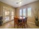Cozy dining area with a round wooden table, four chairs, and bright natural light from adjacent windows and patio doors at 12826 W La Vina Dr, Sun City West, AZ 85375
