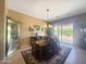Bright dining room features elegant chandelier, wood table, and sliding glass doors to outdoors at 12826 W La Vina Dr, Sun City West, AZ 85375