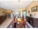 A dining room area with a wooden table set, chandelier, and a view into the kitchen at 12826 W La Vina Dr, Sun City West, AZ 85375