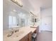 A bright and spacious main bathroom with dual vanities, mirrors, and access to the shower and bathtub at 12826 W La Vina Dr, Sun City West, AZ 85375