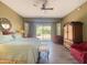 A spacious main bedroom with a ceiling fan, a sitting area, and a door to the backyard at 12826 W La Vina Dr, Sun City West, AZ 85375