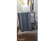 Side view of a gray air conditioner unit with an access panel in a gravel filled space at 14977 W Charter Oak Rd, Surprise, AZ 85379