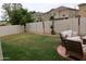 Lush backyard featuring a patio set, green grass, and privacy walls at 14977 W Charter Oak Rd, Surprise, AZ 85379