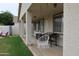 Covered patio showcasing a hanging chair, grill, and outdoor seating area overlooking the spacious backyard at 14977 W Charter Oak Rd, Surprise, AZ 85379