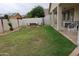 Spacious backyard featuring a patio area with outdoor furniture, green grass, and privacy walls at 14977 W Charter Oak Rd, Surprise, AZ 85379