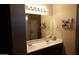 Bathroom vanity with dual sinks, good lighting, and storage for personal items at 14977 W Charter Oak Rd, Surprise, AZ 85379