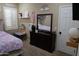 Bright bedroom showcasing a dresser with mirror, a cozy bed, and a window with white shutters at 14977 W Charter Oak Rd, Surprise, AZ 85379