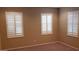 Bright bedroom featuring three windows with plantation shutters and neutral walls at 14977 W Charter Oak Rd, Surprise, AZ 85379