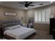 Cozy bedroom features a plush bed, ceiling fan, and stylish window shutters at 14977 W Charter Oak Rd, Surprise, AZ 85379