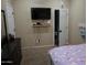 Inviting bedroom featuring a mounted TV, comfortable bed, and neutral wall colors at 14977 W Charter Oak Rd, Surprise, AZ 85379