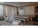 Bright dining area with a long table, bench seating, and stylish lighting fixtures at 14977 W Charter Oak Rd, Surprise, AZ 85379